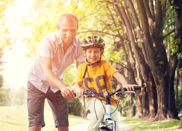 父が息子の自転車に乗ることを学ぶ — ストック写真