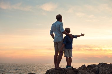 Baba ve oğul günbatımı üzerinde seyir