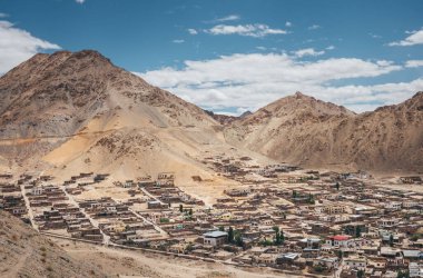 Kuzey Hindistan 'da, Ladakh bölgesinde, güneşli bir günde 2016 yılında çöl manzaralı ve mavi gökyüzü altında Himalaya dağlarının engebeli bir vadisine yerleşmiş olan Leh şehrinin panoramik yüksek açılı manzarası.