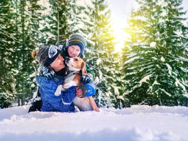 Mother with son and dog in snow forest — Stock Photo, Image