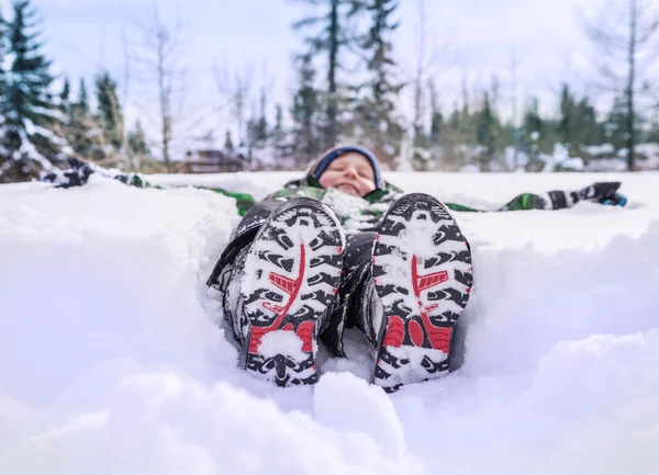 Kluk leží v hlubokém sněhu — Stock fotografie