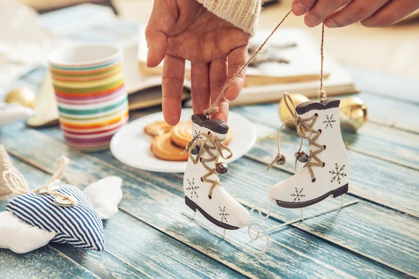 Woman hands with miniature ice skates — Stock Photo, Image