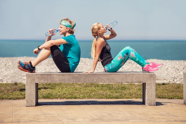 Man and woman drink  water after  training — Stock Photo, Image