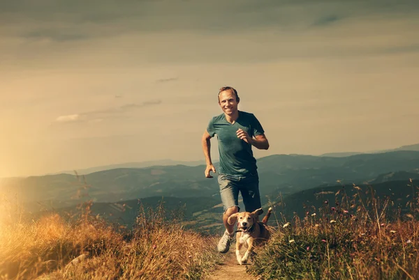 Mann läuft mit Hund — Stockfoto