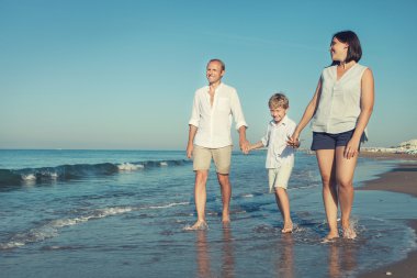 Aile birlikte deniz kıyısında yürüyüş