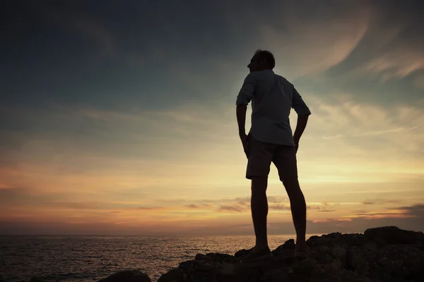 Homme sur la côte de la mer au coucher du soleil — Photo