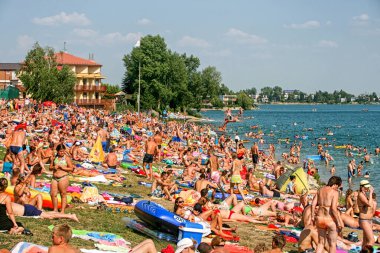 SENEC, SLOVAKIA - 2 AĞUSTOS 2009: Güneşli göllerde güneşlenen insanlarla dolu kalabalık plaj
