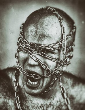Kafası zincirlenmiş bağıran adamın psikotik bakışı..