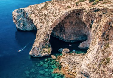 Malta 'nın güney kıyısındaki mavi Grotto deniz mağarası dramatik kireçtaşı uçurumları ve canlı mavi Akdeniz suları güneş ışığını, popüler turizm beldelerini ve doğal harikaları yansıtıyor..