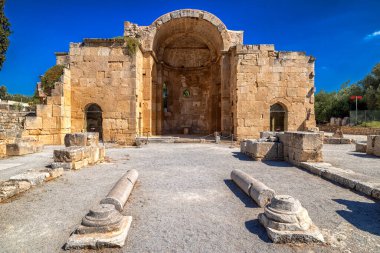 Girit adasındaki Gortys arkeolojik alanındaki taş tapınağın antik kalıntıları, mavi yaz gökyüzünün altında sütunları ve duvarları olan eski tarihi mimari.