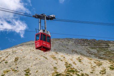 Tatranska Lomnica, Slovakya - 21 Haziran 2025: High Tatras dağlarında hareket eden teleferik kırmızı kabini.
