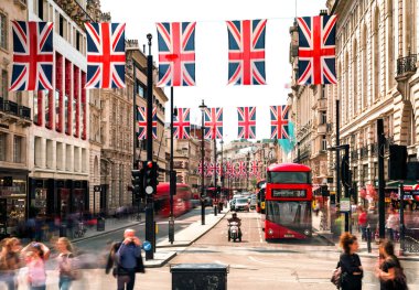 Londra, Birleşik Krallık - 14 Mayıs 2018: İkonik kırmızı çift katlı otobüs, Union Jack bayrakları ve Londra 'nın merkezindeki Piccadilly Sirki' nde insanlar.