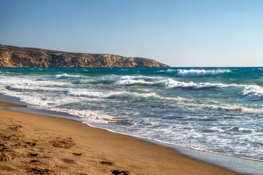 Kalamaki, Girit, Yunanistan 'da turkuvaz dalgaları ve altın kumlarla dolu güneşli Akdeniz plajı, aydınlık bir yaz gününde yakalandı.