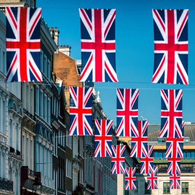 Londra, Birleşik Krallık - 15 Mayıs 2018: Güneşli bir günde tarihi mimarisi olan İngiliz Birliği bayrakları şehir caddesinin üzerinde asılı