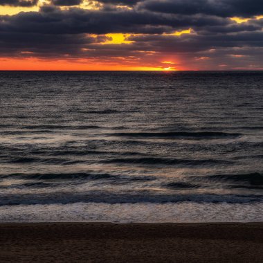Bulgaristan 'ın Obzor kentinde yumuşak dalgalar ve hafif altın ışıkla sakin bir denizin üzerinde gün doğumu. Minimum deniz manzarası huzurlu ve meditasyon havası yaratıyor..