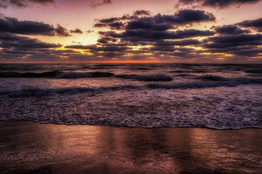 Bulgaristan 'ın Obzor kentindeki kumlu plajda gün doğumu parlak ve dramatik bulutlar yükseliyor. Enerjik sahil sabah atmosferi.