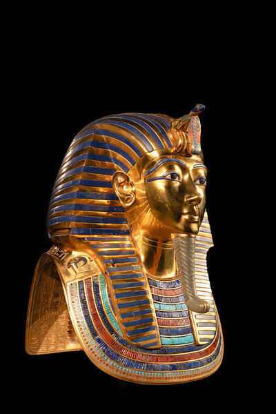 Side view of Tutankhamun golden funerary mask against a black background, showing detailed ancient Egyptian craftsmanship, royal symbolism and clean copy space suitable for design use.