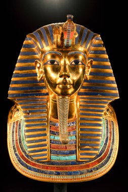 Renkli işlemeli ve sembolik elementlerle Tutankamon 'un altın maskesi. Görüntü, antik Mısır firavunlarının ikonik işçiliğini ve ayrıntılı sanat dekorasyonunu vurguluyor..