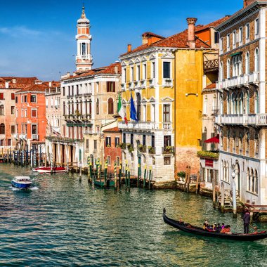 Venedik, İtalya - 11 Şubat 2018: Gondol turistlerle Büyük Kanal boyunca seyahat ediyor, etrafları renkli tarihi binalar ve geleneksel Venedik mimarisi ile çevrili..