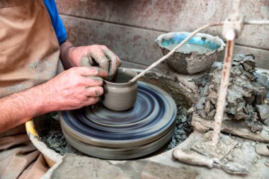 Yunanistan 'ın Girit kentindeki Margarit çömlek köyü. Geleneksel seramik atölyesi, dönen çarkın üzerindeki çömlekçi şekilli kil, otantik el yapımı çömlek ve zanaatkarlığı temsil ediyor..