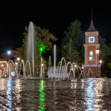 Obzor, Bulgaristan - 20 Eylül 2025: Deniz kıyısındaki Obzor tatil beldesinde, şehir meydanındaki aydınlık çeşme ve saat kulesi.