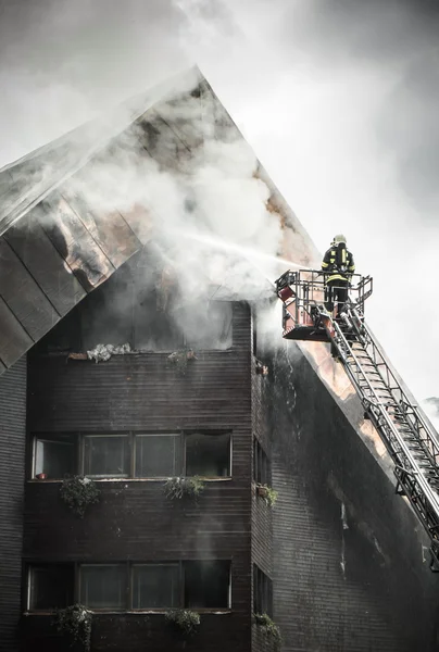 Bombeiro e telhado em chamas — Fotografia de Stock