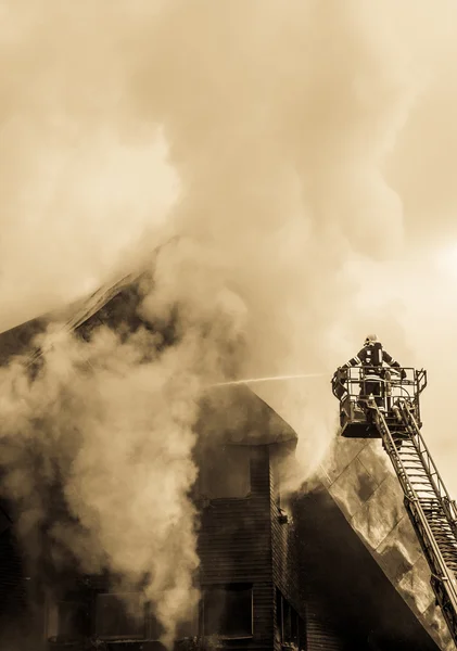 Пожежник і палаючий дах — стокове фото