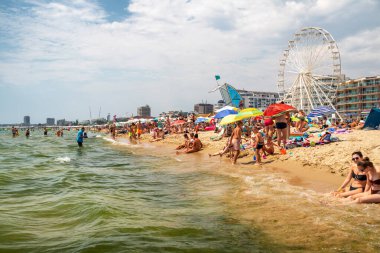 Sunny Beach, Bulgaristan - 17 Temmuz 2025: Büyük turist kalabalığı popüler Sunny Beach tatil beldesinde, Karadeniz 'in kalabalık kıyı şeridi boyunca yüzüyor ve dinleniyor.