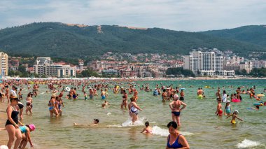 Sunny Beach, Bulgaristan - 17 Temmuz 2025: Turistler, popüler Sunny Beach tatil beldesinde en yoğun yaz sezonunda Karadeniz kıyılarını doldurarak dinleniyor, yüzüyor ve güneşleniyor.