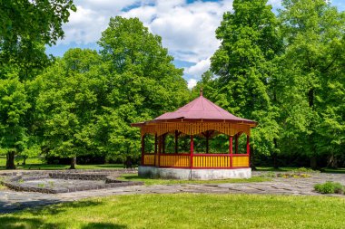 Slovakya 'nın Liptov bölgesindeki Lubochna köyünde yemyeşil ağaçlarla çevrili sessiz bir parkta ahşap bir çardak. Yaz doğasında rahatlama, dinlenme ve rahatlama için huzurlu bir açık alan..
