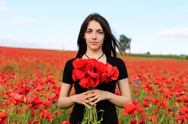 Joven mujer feliz con un ramo de amapolas rojas — Foto de Stock