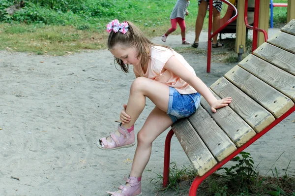 Pequeña niña mira su moretón —  Fotos de Stock