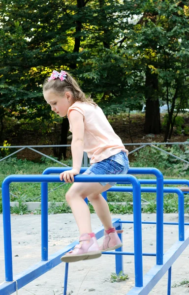 Small girl doing sports exercises in the park — Stock Photo, Image