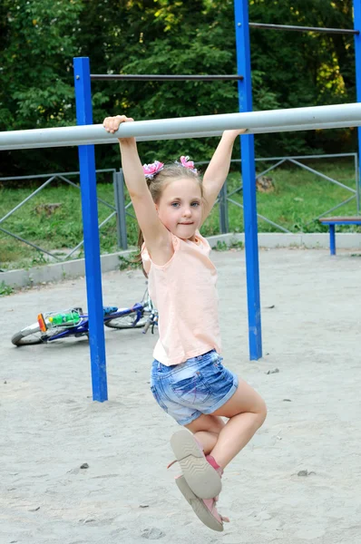 Menina pequena fazendo exercícios esportivos no parque Imagem De Stock