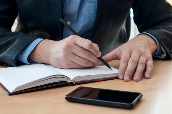 Man writes something in a notebook — Stock Photo, Image