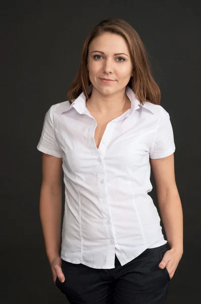 Young woman in a white shirt against grey background — Stock Photo, Image