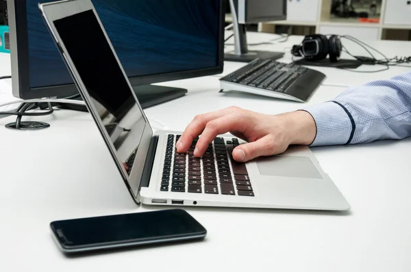 Mann tippt mit der Hand auf Laptop — Stockfoto