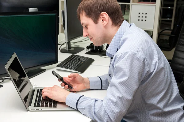 Knappe jongeman met computer in het kantoor. Programmering — Stockfoto
