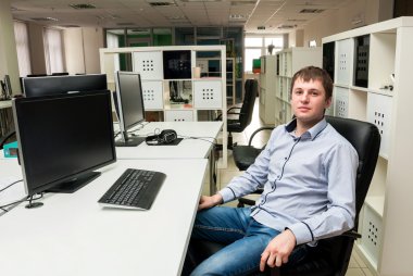 Ofiste genç yakışıklı mutlu adam. Programmin