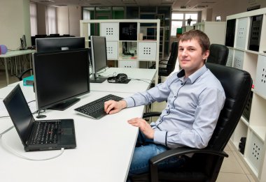 Ofiste genç yakışıklı mutlu adam. Programmin