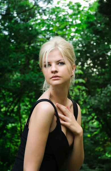 Joven mujer rubia de moda posando en el parque — Foto de Stock