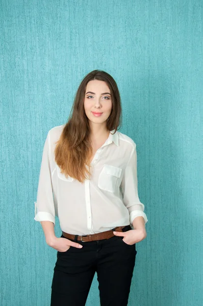 Young woman in white blouse near blue wall — Stock Photo, Image