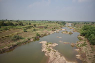 Köprünün altında tarım arazisi olan küçük bir nehir kanalı..