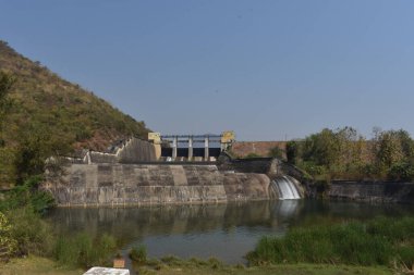 Güneşli bir günde harika görünen eski bir baraj manzarası. Rezervuardan akan suyla birlikte Hint barajı. Bu baraj tüm yıl boyunca ulaşılabilirlik suyuyla ünlüdür.. 