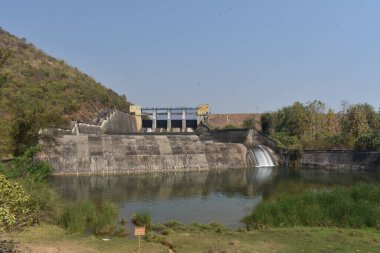 Güneşli bir günde harika görünen eski bir baraj manzarası. Rezervuardan akan suyla birlikte Hint barajı. Bu baraj tüm yıl boyunca ulaşılabilirlik suyuyla ünlüdür.. 