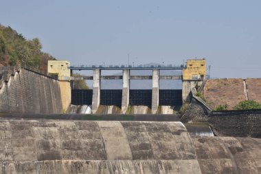 Güneşli bir günde harika görünen eski bir baraj manzarası. Rezervuardan akan suyla birlikte Hint barajı. Bu baraj tüm yıl boyunca ulaşılabilirlik suyuyla ünlüdür.. 