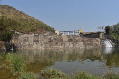 Güneşli bir günde harika görünen eski bir baraj manzarası. Rezervuardan akan suyla birlikte Hint barajı. Bu baraj tüm yıl boyunca ulaşılabilirlik suyuyla ünlüdür.. 