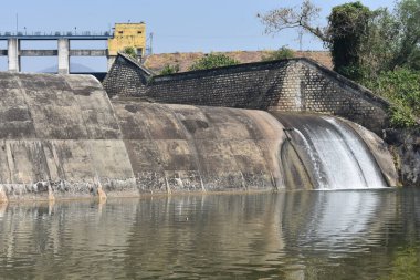 Güneşli bir günde harika görünen eski bir baraj manzarası. Rezervuardan akan suyla birlikte Hint barajı. Bu baraj tüm yıl boyunca ulaşılabilirlik suyuyla ünlüdür.. 