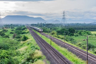 Yağmur mevsiminde güzel manzarayla dramatik gökyüzü altında demiryolu ufka..