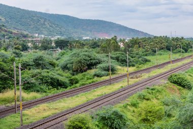 Yağmur mevsiminde güzel manzarayla dramatik gökyüzü altında demiryolu ufka..